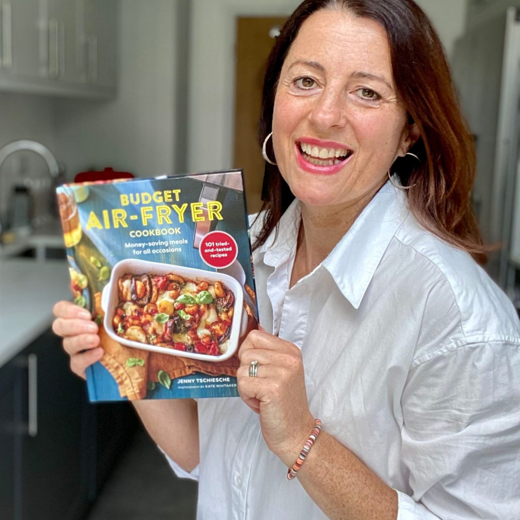 Jenny Tschiesche holding her book entitled Budget Air Fryer Cookbook